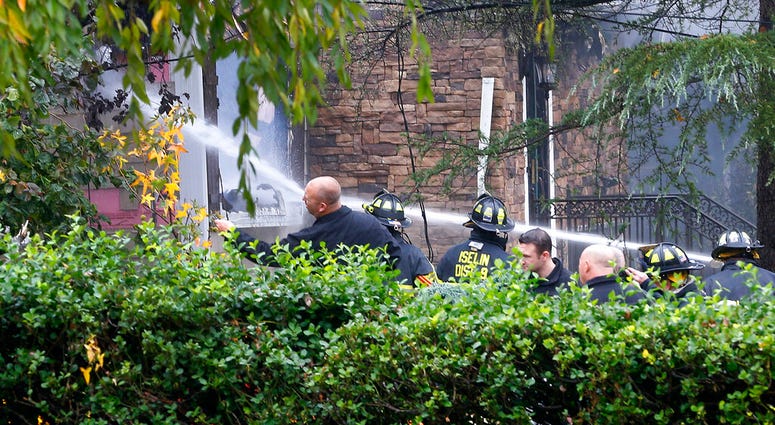 Woodbridge firefighters work to extinguish the scene of a plane crash at a home in Woodbridge, N.J., Tuesday, Oct. 29, 2019.