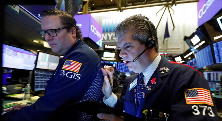 In this Tuesday, Oct. 29, 2019, file photo specialist Gregg Maloney, left, and trader John Panin work on the floor of the New York Stock Exchange. (AP Photo/Richard Drew, File)