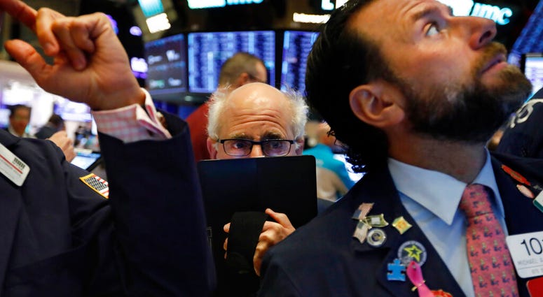 Trader Peter Tuchman, center, works on the floor of the New York Stock Exchange, Monday, Nov. 4, 2019. Stocks are opening higher on Wall Street, pushing major indexes toward more record highs. (AP Photo/Richard Drew)