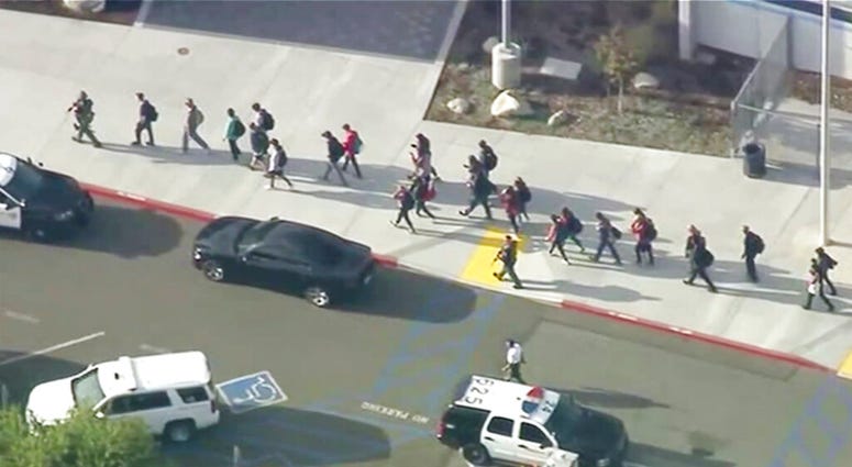 People are led out of Saugus High School after reports of a shooting on Thursday, Nov. 14, 2019 in Santa Clarita, Calif. (KTTV-TV via AP)