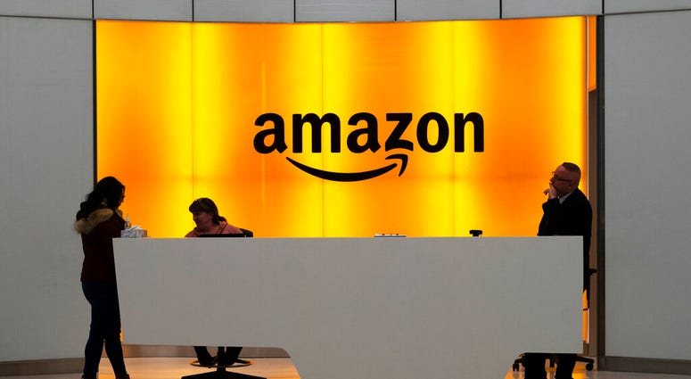 FILE - In this Feb. 14, 2019, file photo people stand in the lobby for Amazon offices in New York. (AP Photo/Mark Lennihan, File) FILE - In this Feb. 14, 2019, file photo people stand in the lobby for Amazon offices in New York. (AP Photo/Mark Lennihan, File)