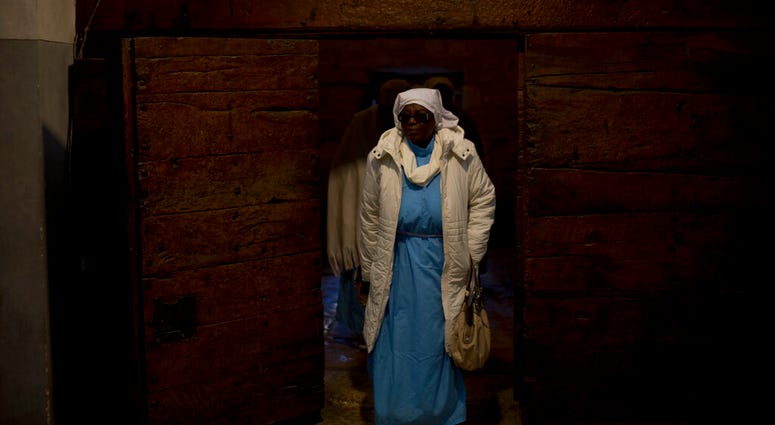 A Christian pilgrim from Nigeria enters the Church of the Nativity, built on top of the site where Christians believe Jesus Christ was born, on Christmas Eve in the West Bank City of Bethlehem, Tuesday, Dec. 24, 2019. (AP Photo/Majdi Mohammed) A Christian pilgrim from Nigeria enters the Church of the Nativity, built on top of the site where Christians believe Jesus Christ was born, on Christmas Eve in the West Bank City of Bethlehem, Tuesday, Dec. 24, 2019. (AP Photo/Majdi Mohammed)