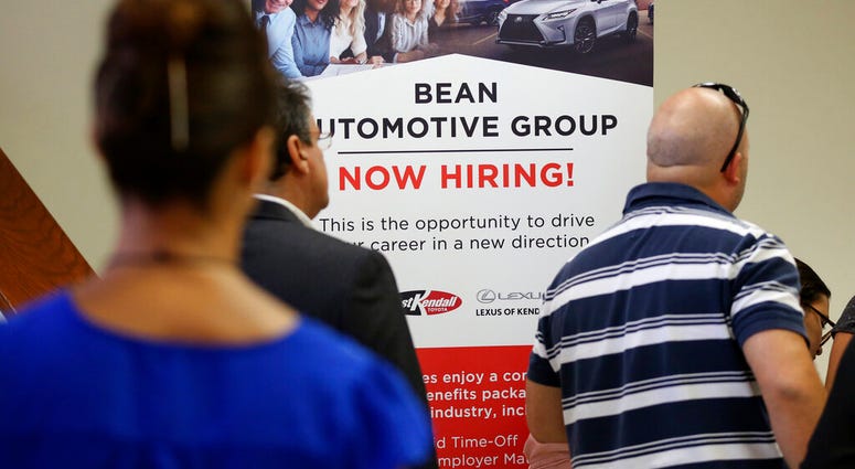 FILE - In this Sept. 18, 2019, file photo people stand in line to inquire about jobs available at the Bean Automotive Group during a job fair in Miami. On Friday, Jan. 10, 2020, the U.S. government issues the December jobs report. (