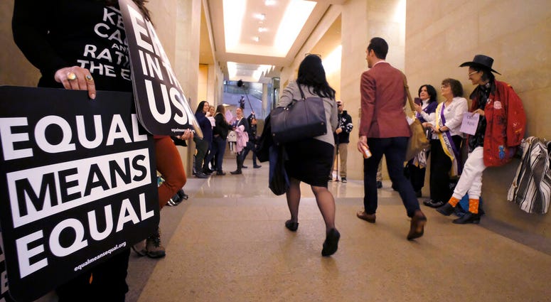 An Equal Rights Amendment supporters yell encouragement to two legislators as they walk down a hallway inside the state Capitol in Richmond, Va., Tuesday, Jan. 14, 2020. (Bob Brown/Richmond Times-Dispatch via AP) An Equal Rights Amendment supporters yell encouragement to two legislators as they walk down a hallway inside the state Capitol in Richmond, Va., Tuesday, Jan. 14, 2020. (Bob Brown/Richmond Times-Dispatch via AP)
