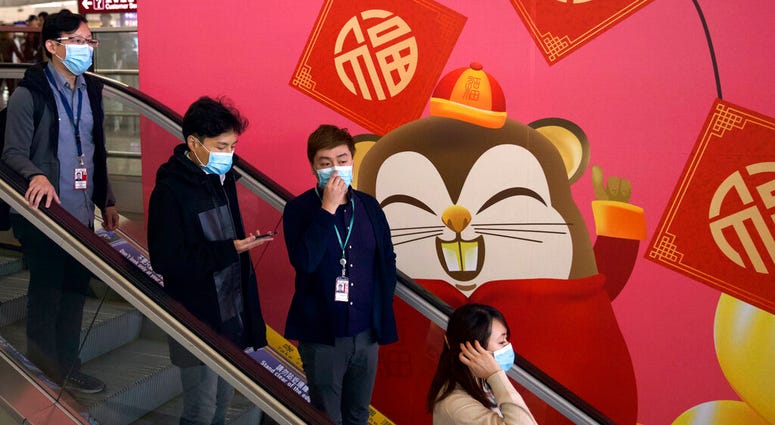 People wear face masks as they ride an escalator at the Hong Kong International Airport in Hong Kong, Tuesday, Jan. 21, 2020. (AP Photo/Ng Han Guan) People wear face masks as they ride an escalator at the Hong Kong International Airport in Hong Kong, Tuesday, Jan. 21, 2020. .(AP Photo/Ng Han Guan)