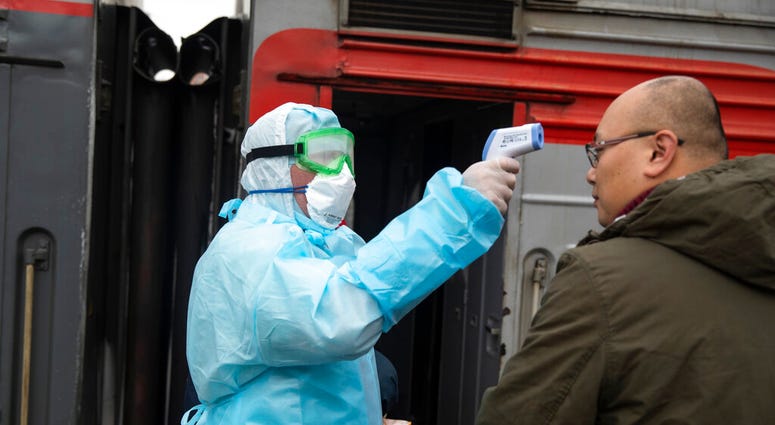 A medical worker in a hazardous materials suit uses a body thermal scanner to check temperature of Chinese passenger who just arrived from Beijing at the Yaroslavsky railway station in Moscow, Russia, Friday, Jan. 31, 2020. (AP Photo/Pavel Golovkin) A medical worker in a hazardous materials suit uses a body thermal scanner to check temperature of Chinese passenger who just arrived from Beijing at the Yaroslavsky railway station in Moscow, Russia, Friday, Jan. 31, 2020. (AP Photo/Pavel Golovkin)