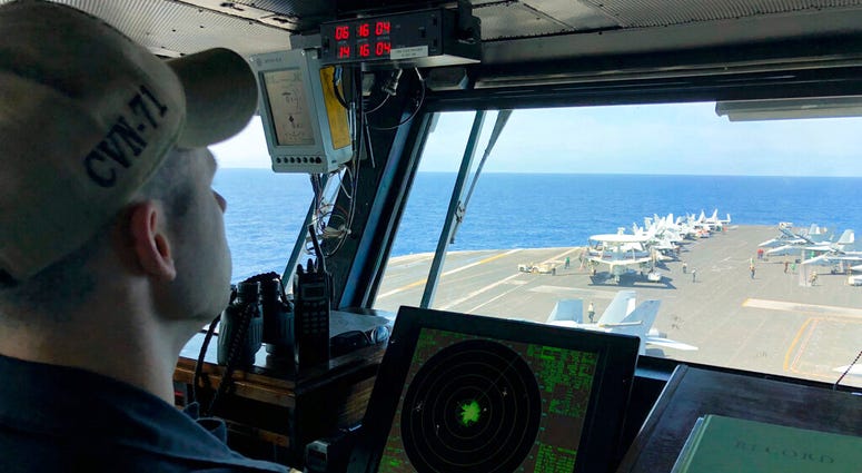 FILE - In this April 10, 2018, file photo, a U.S. Navy crewman monitors on the deck of the U.S. aircraft carrier Theodore Roosevelt in international waters off South China Sea.