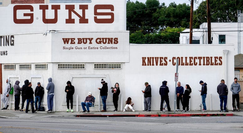 People wait in a line to enter a gun store in Culver City, Calif., March 15, 2020.