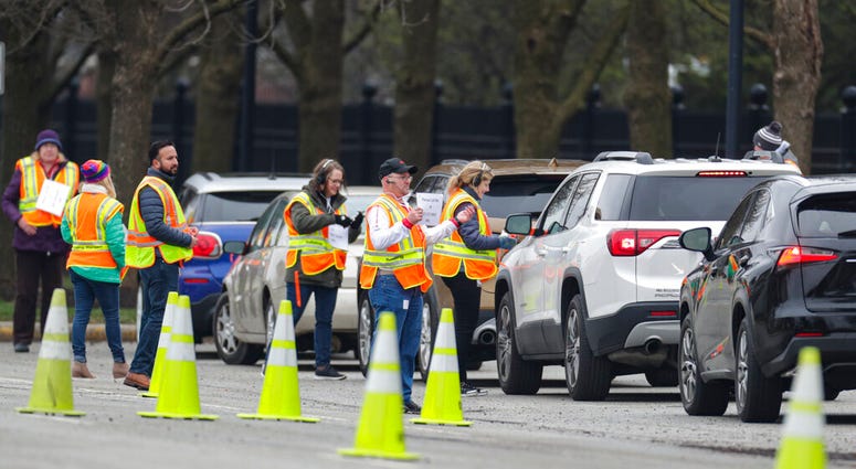 Employees of Eli Lilly check in members of the healthcare community as they begin drive-through testing for COVID-19, the disease caused by the new coronavirus, at the company headquarters in Indianapolis, Monday, March 23, 2020. (AP Photo/Michael Conroy) Employees of Eli Lilly check in members of the healthcare community as they begin drive-through testing for COVID-19, the disease caused by the new coronavirus, at the company headquarters in Indianapolis, Monday, March 23, 2020. (AP Photo/Michael Conroy)