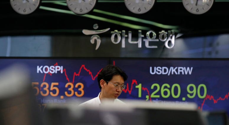 A currency trader walks by screens showing the Korea Composite Stock Price Index (KOSPI), left, and the foreign exchange rate between U.S. dollar and South Korean won at the foreign exchange dealing room in Seoul, March 24, 2020. (AP Photo/Lee Jin-man) A currency trader walks by screens showing the Korea Composite Stock Price Index (KOSPI), left, and the foreign exchange rate between U.S. dollar and South Korean won at the foreign exchange dealing room in Seoul, March 24, 2020. (AP Photo/Lee Jin-man)
