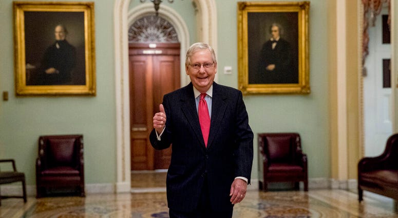 Senate Majority Leader Mitch McConnell of Ky. gives a thumbs up as he arrives on Capitol Hill, Wednesday, March 25, 2020, in Washington.