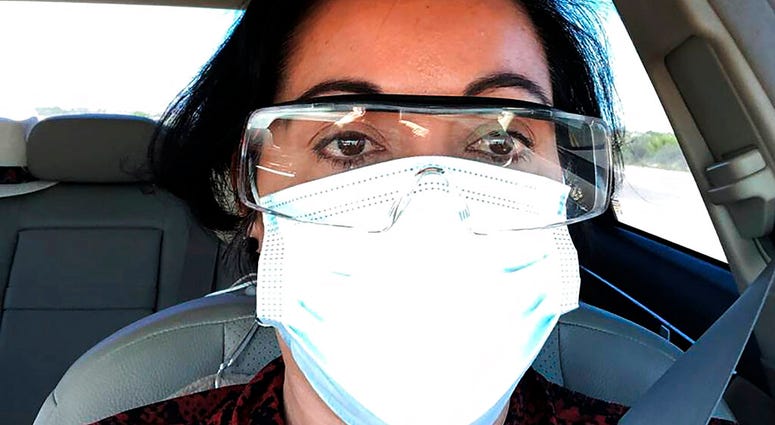 This March 23, 2020 photo provided by Margarita Silva shows her outside the La Palma Detention Center in Eloy, Ariz., wearing her husband’s land surveyor goggles, a mask she borrowed from a friend and medical gloves she got from a hardware store