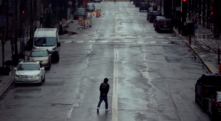 In this April 3, 2020, file photo a man crosses an empty street in downtown Kansas City, Mo. (AP Photo/Charlie Riedel, File) In this April 3, 2020, file photo a man crosses an empty street in downtown Kansas City, Mo. (AP Photo/Charlie Riedel, File)