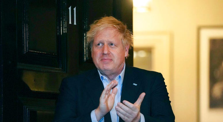 FILE - In this Thursday, April 2, 2020 handout photo provided by 10 Downing Street, Britain's Prime Minister Boris Johnson claps outside 11 Downing Street to salute local heroes during Thursday's nationwide Clap for Carers NHS initiative to applaud worker