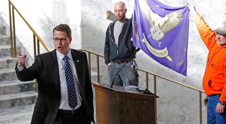 FILE - In this Friday, Feb. 15, 2019 file photo, Washington state Rep. Matt Shea, R-Spokane Valley, gestures as he gives a speech in front of the liberty state flag at the Capitol in Olympia, Wash. (AP Photo/Ted S. Warren, File) FILE - In this Friday, Feb. 15, 2019 file photo, Washington state Rep. Matt Shea, R-Spokane Valley, gestures as he gives a speech in front of the liberty state flag at the Capitol in Olympia, Wash. (AP Photo/Ted S. Warren, File)