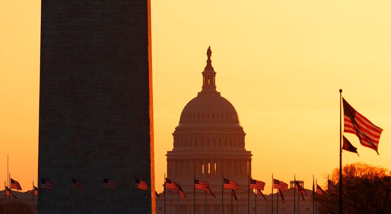 FILE - In this March 18, 2020, file photo, the Washington Monument and the U.S. Capitol are seen in Washington, at sunrise.