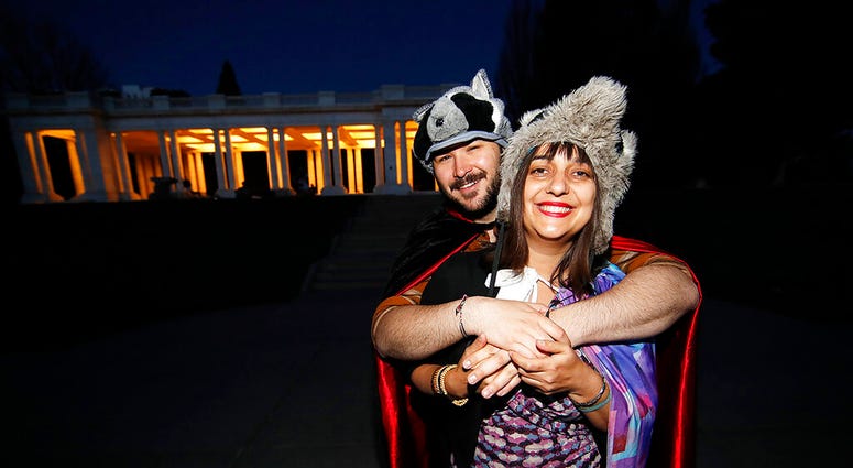 n this Wednesday, April 8, 2020, photograph, Brice Maiurro, back, hugs Shelsea Ochoa after they led a howl in Cheesman Park in Denver as a statewide stay-at-home order remained in effect in an effort to reduce the spread of the coronavirus.