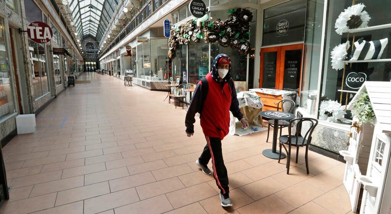 A man walks through the 5th Street Arcade, a selection of indoor shops closed during the pandemic, Thursday, May 7, 2020, in Cleveland.