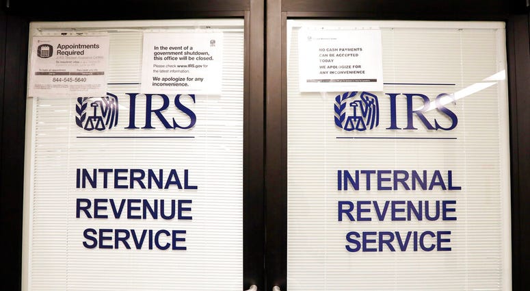 FILE - In this Jan. 16, 2019, file photo, doors at the Internal Revenue Service (IRS) in the Henry M. Jackson Federal Building are locked and covered with blinds as a sign posted advises that the office will be closed during the partial government shutdow