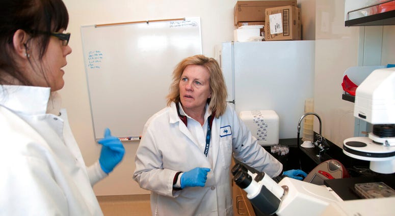 FILE - In this Feb. 28, 2011, file photo, Director of research Judy Mikovits talks to a graduate student and research associate in the lab, at the Whittemore Peterson Institute for Neuro-Immune Disease, in Reno, Nev. T