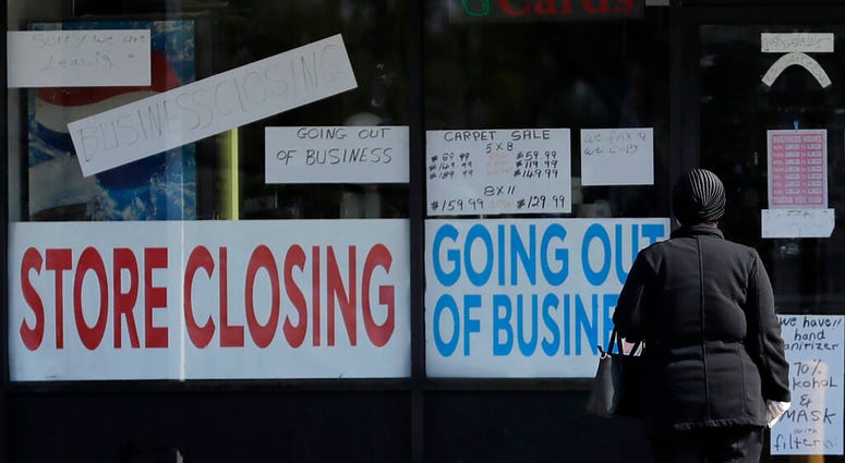 A woman looks at signs at a store closed due to COVID-19 in Niles, Ill., Wednesday, May 13, 2020. (AP Photo/Nam Y. Huh) A woman looks at signs at a store closed due to COVID-19 in Niles, Ill., Wednesday, May 13, 2020. (AP Photo/Nam Y. Huh)