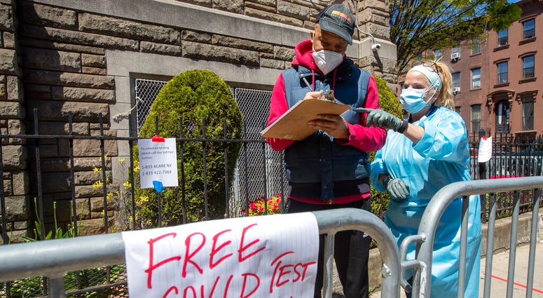 Medical personnel help residents sign in for a COVID-19 test at the Bethany Baptist Church, Wednesday, May 13, 2020, in the Bedford-Stuyvesant neighborhood of the Brooklyn borough of New York.
