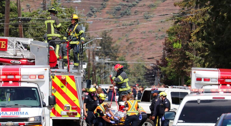 First responders transport an injured person on a stretcher at the scene of a crash involving a Canadian Forces Snowbirds aircraft in Kamloops, British Columbia, Sunday, May 17, 2020.