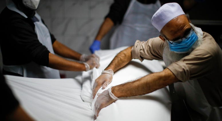 The body of Mohammad Altaf, who died at 48 of COVID-19, is ritually washed and wrapped before being given funeral prayers at Al-Rayaan Muslim Funeral Services, Sunday, May 17, 2020, in the Brooklyn borough of New York.