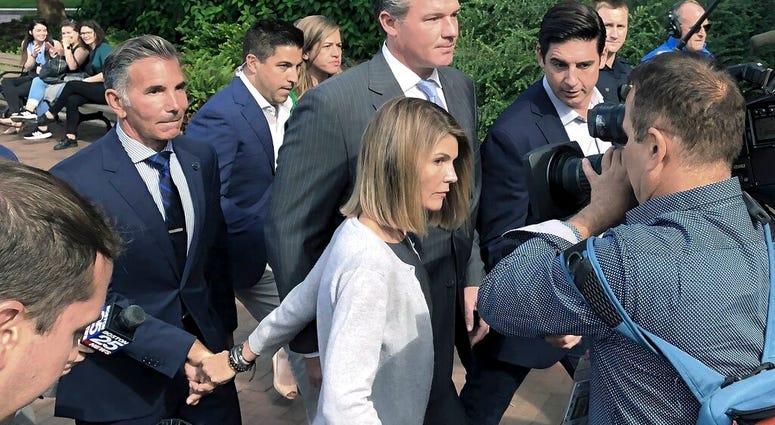 In this Aug. 27, 2019, file photo, Lori Loughlin departs federal court with her husband, clothing designer Mossimo Giannulli, left, in Boston, after a hearing in a nationwide college admissions bribery scandal. (AP Photo/Philip Marcelo, File) In this Aug. 27, 2019, file photo, Lori Loughlin departs federal court with her husband, clothing designer Mossimo Giannulli, left, in Boston, after a hearing in a nationwide college admissions bribery scandal. (AP Photo/Philip Marcelo, File)