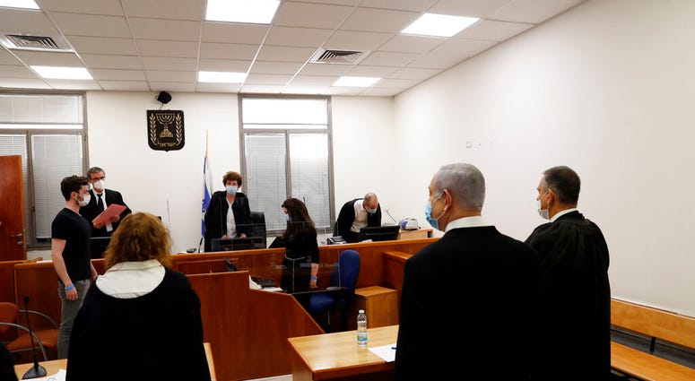 sraeli Prime Minister Benjamin Netanyahu, second right, stands while the judges enter the court room as his corruption trial opens at the Jerusalem District Court, Sunday, May 24, 2020.