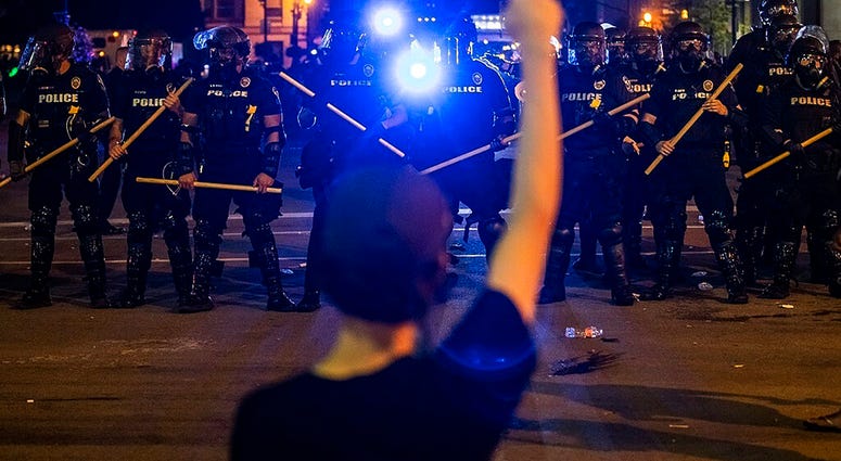 Police hold off protesters for Breonna Taylor, early Friday, May 29, 2020 in Louisville, Ky. Taylor, a black woman, was fatally shot by police in her home in March.