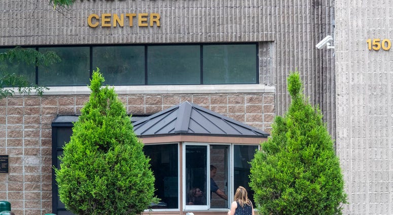 FILE - In this Aug. 13, 2019 file photo, an employee checks a visitor outside the Metropolitan Correctional Center in New York.