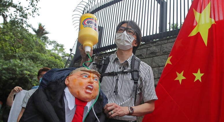 Pro-China supporters hold the effigy of U.S. President Donald Trump and Chinese national flag outside the U.S. Consulate during a protest in Hong Kong, Saturday, May 30, 2020.