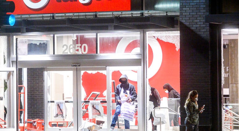 People leave a vandalized Target store in Oakland, Calif., on Saturday, May 30, 2020, during protests against the death of George Floyd, a handcuffed black man in police custody in Minneapolis.