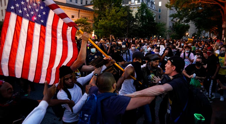 Demonstrators clash as people gather to protest the death of George Floyd, Saturday, May 30, 2020, near the White House in Washington.