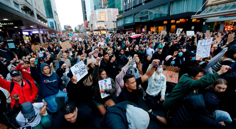 Demonstrators hold placards during a march in central Auckland, New Zealand, Monday, June 1. 2020, to protest the death of United States' George Floyd, a black man who died in police custody in Minneapolis on May 25.