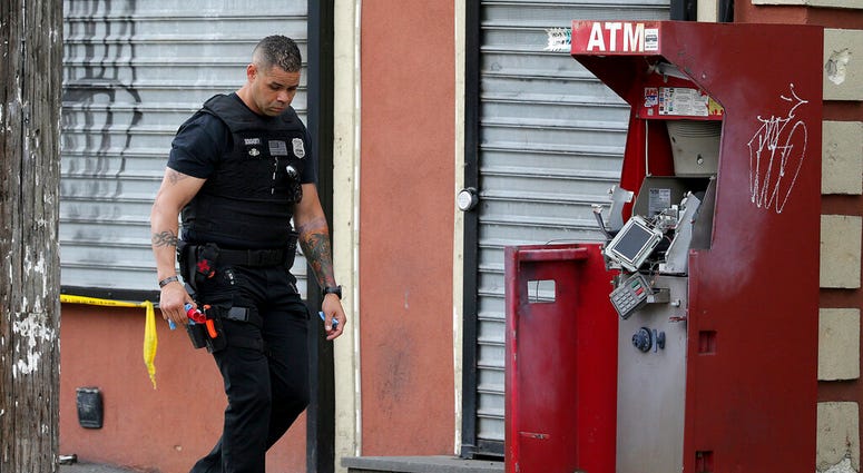 A member of the Philadelphia bomb squad surveys the scene after an ATM machine was blown-up at 2207 N. 2nd Street in Philadelphia, Tuesday, June 2, 2020.