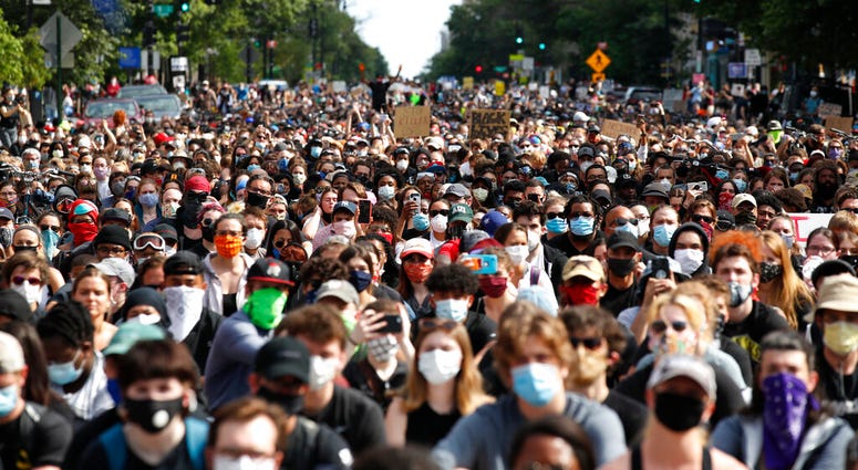 Demonstrators pause to kneel as they march to protest the death of George Floyd, Tuesday, June 2, 2020, in Washington. Floyd died after being restrained by Minneapolis police officers.