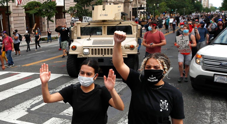 Demonstrators march as they protest the death of George Floyd, Tuesday, June 2, 2020, in Washington. Floyd died after being restrained by Minneapolis police officers.