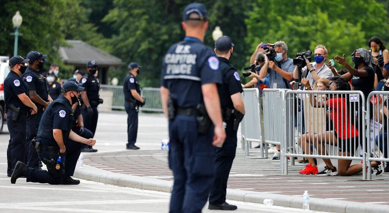 Members of the capitol police kneel as demonstrators gather to protest the death of George Floyd, Wednesday, June 3, 2020, outside the U.S. Capitol in Washington.