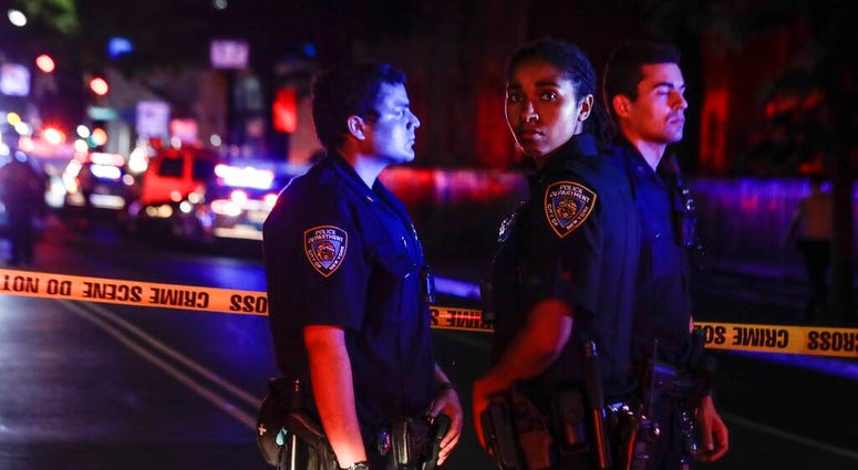 New York City police stand on a street early Thursday, June 4, 2020, in the Brooklyn borough of New York, after a police officer was shot. The police department says an officer has been shot in Brooklyn.