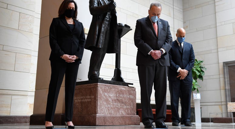 Standing near a statue of Frederick Douglass, Sen. Kamala Harris, D-Calif., left, Senate Minority Leader Sen. Chuck Schumer of N.Y., center, and Sen. Cory Booker, D-N.J.,, right, pause during a prayer Capitol Hill in Washington, Thursday, June 4, 2020, du