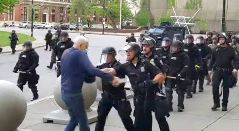 In this image from video provided by WBFO, a Buffalo police officer appears to shove a man who walked up to police Thursday, June 4, 2020, in Buffalo, N.Y. Video from WBFO shows the man appearing to hit his head on the pavement, with blood leaking out as