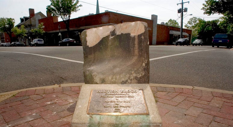 FILE- This May 5, 2005, file photo, shows the historic pre-civil war auction block for slaves and property at the corner of Charles and William Streets in downtown Fredericksburg, Va.