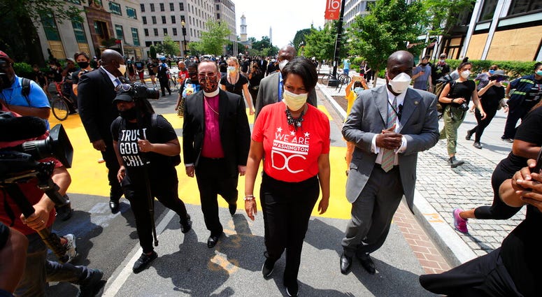 District of Columbia Mayor Muriel Bowser walks on the street leading to the White House after the words Black Lives Matter were painted in enormous bright yellow letters on the street by city workers and activists Friday, June 5, 2020, in Washington.