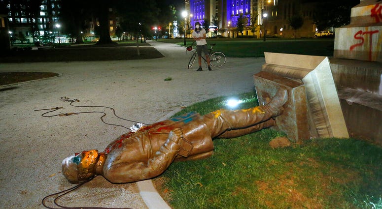 The statue of Confederate Gen. Williams Carter Wickham lies on the ground after protesters pulled it down Saturday, June 6, 2020, in Monroe Park in Richmond, Va. The statue had stood in the park since 1891.