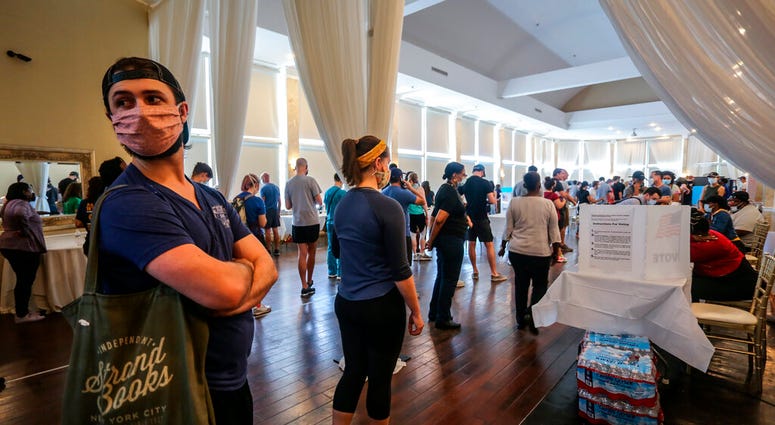 Voters wait in line to cast their ballots in the state's primary election at a polling place, Tuesday, June 9, 2020, in Atlanta, Ga.