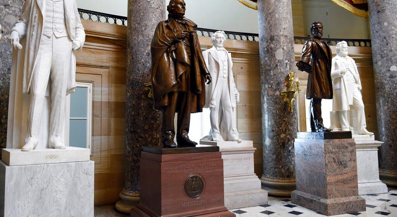 FILE - In this June 24, 2015 file photo, a statue of Jefferson Davis, second from left, president of the Confederate States from 1861 to 1865, is on display in Statuary Hall on Capitol Hill in Washington.