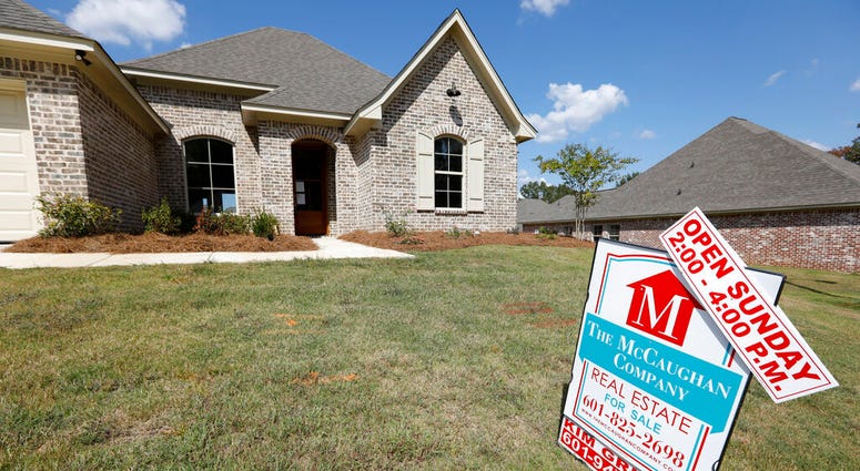 FILE - In this Sept. 25, 2019 file photo, a sign promoting an open house sits atop a realty company's lawn sign in Brandon Miss.