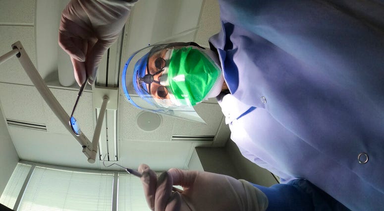 Dr. Terri Tiersky poses for a portrait in full personal protective equipment, double mask, face shield, gown and gloves, at her dentist office in Skokie, Ill., on Friday, June 12, 2020.